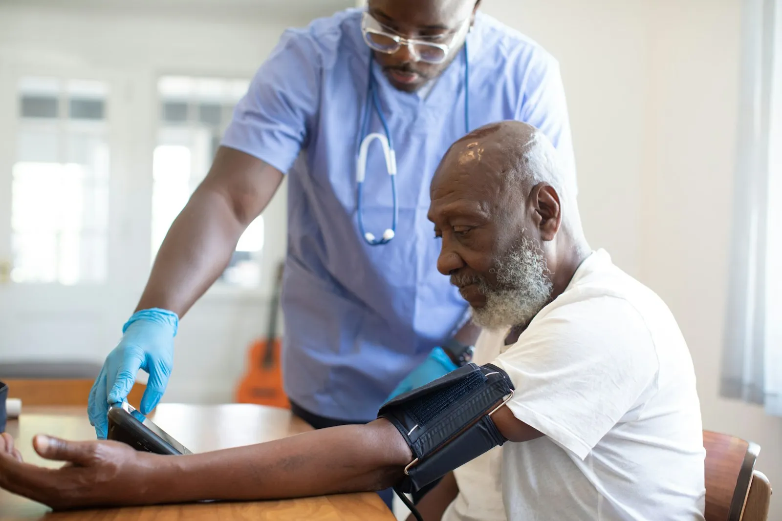 An older patient reviewing notes with a clinician in a bright consulting room