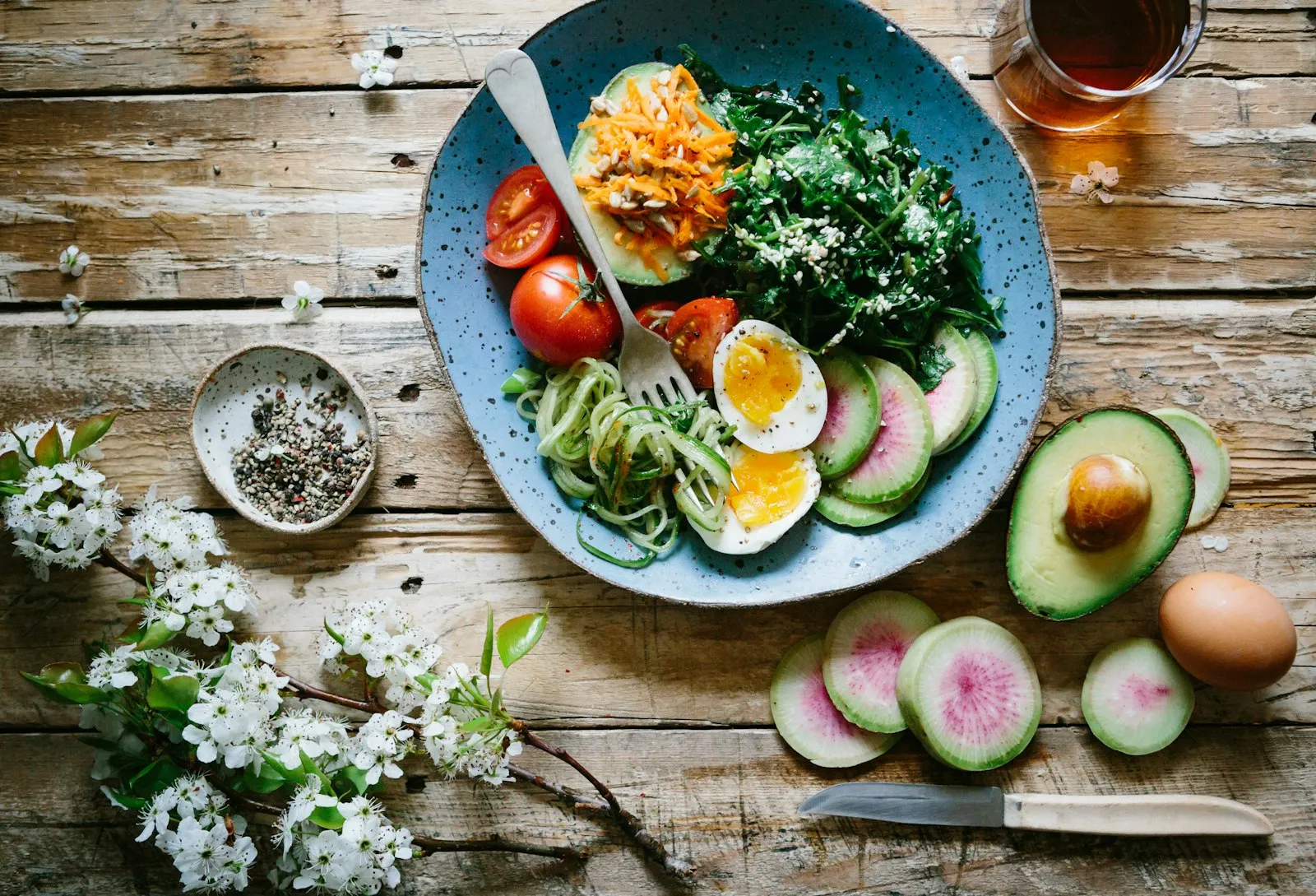 Fresh vegetables, pulses and grains arranged on a wooden kitchen counter