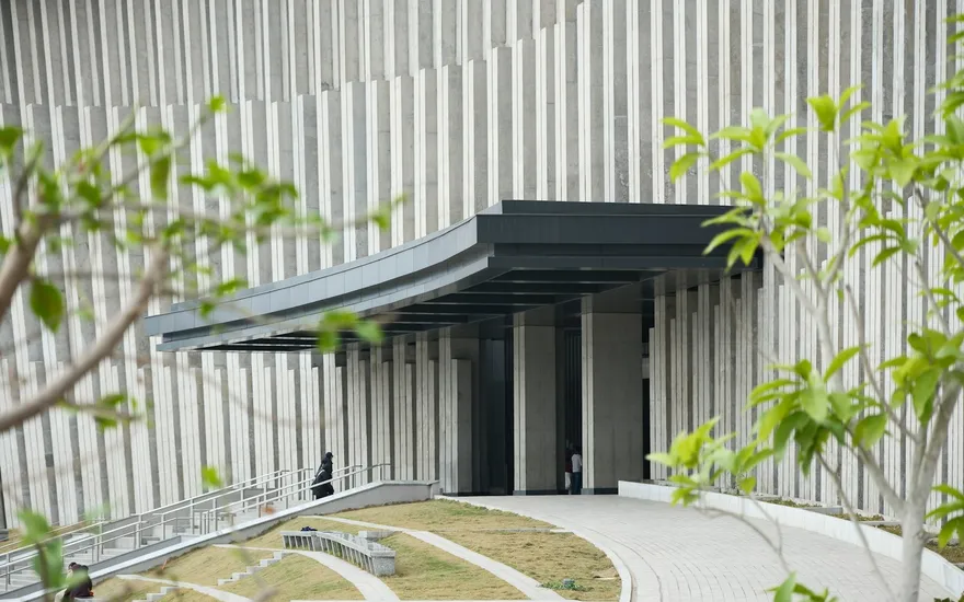 The glass and brick frontage of the Riverside Clinic seen from the street on a bright morning
