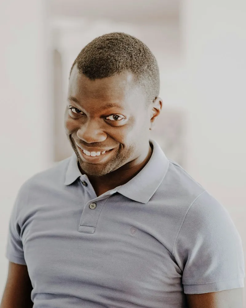 Dr Daniel Mensah photographed in natural light against a plain background