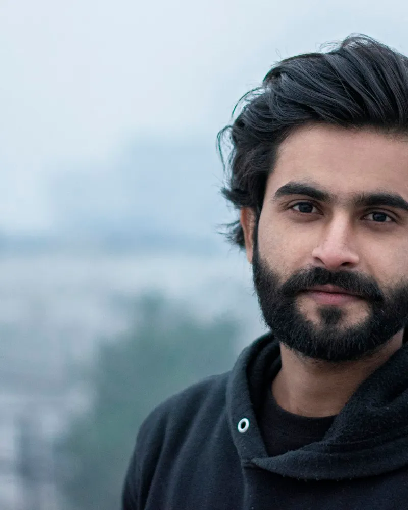 Arun Sandhu photographed in natural light against a plain background